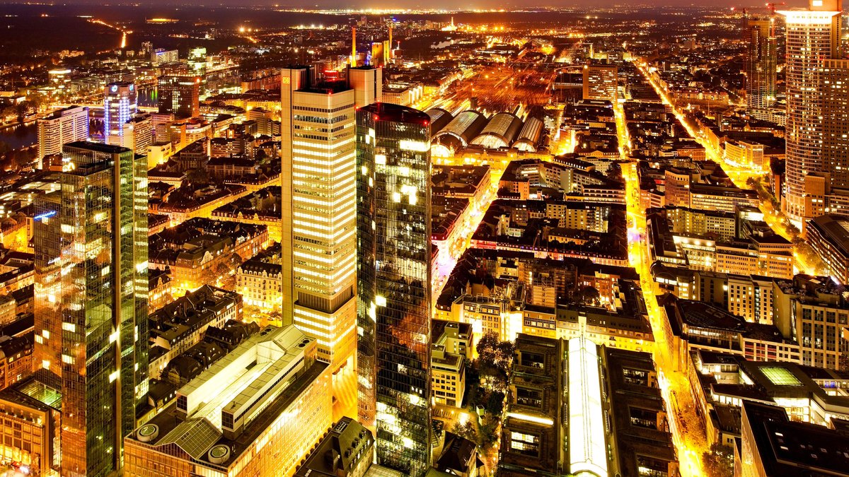 Die Aufnahme zeigt die hell erleuchtete Innenstadt von Frankfurt am Main. 