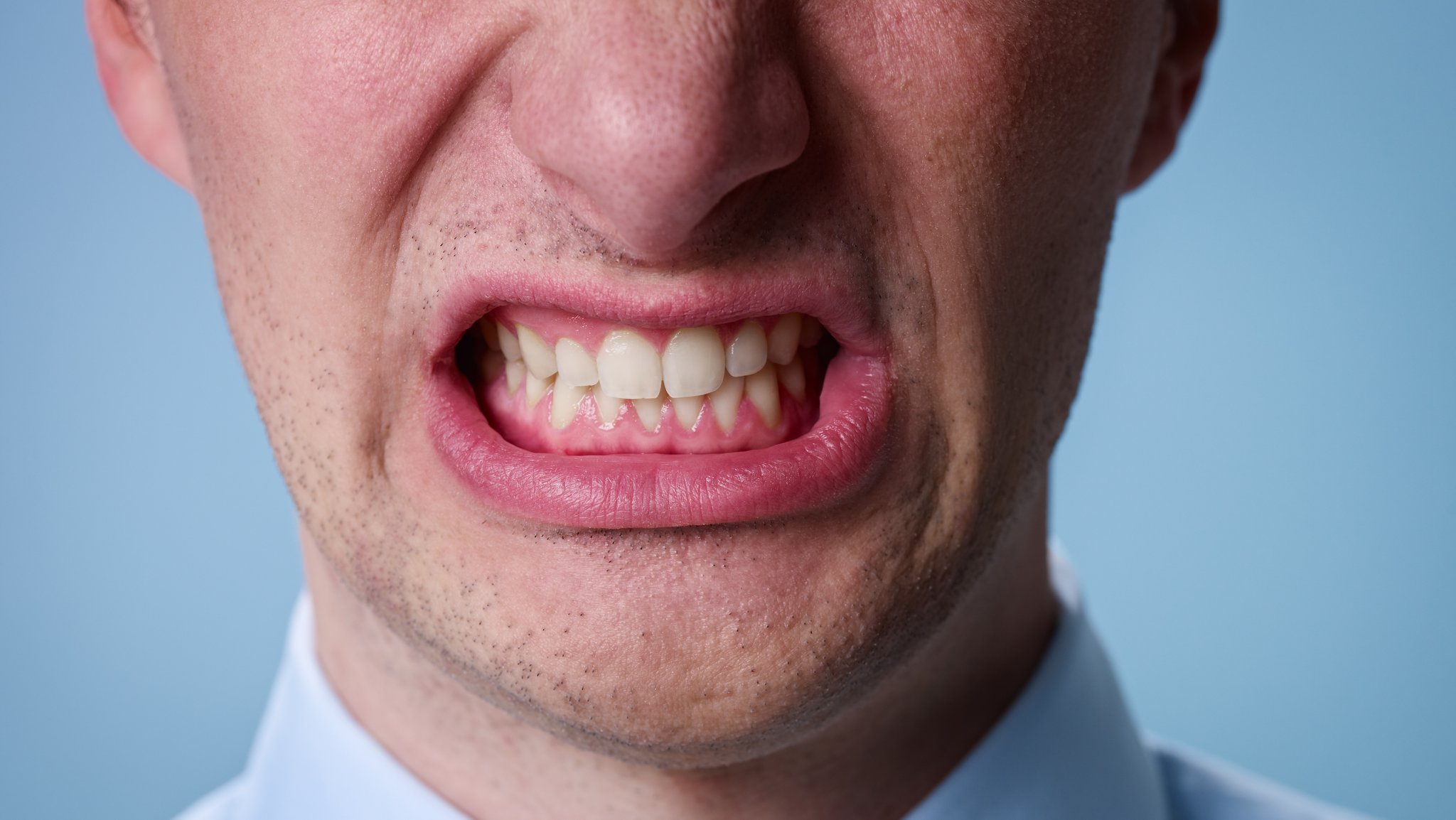 Mann beißt die Zähne zusammen