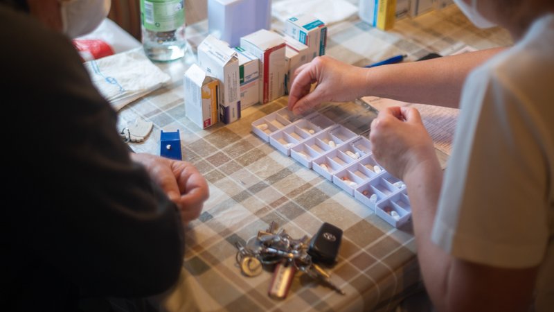 Eine Pflegefachkraft füllt während ihrer Schicht in der ambulanten Pflege neben einem Klienten Medikamente in Schalen (Symbolbild). | Bild: pa/dpa/Sebastian Gollnow Eine Pflegefachkraft füllt während ihrer Schicht in der ambulanten Pflege neben einem Klienten Medikamente in Schalen (Symbolbild).