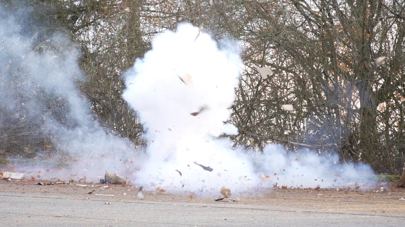 Explodierende Böller. Fetzen fliegen durch die Luft, viel Qualm steigt auf. | Bild: BR/Rudolph Heinz Explodierende Böller. Fetzen fliegen durch die Luft, viel Qualm steigt auf.