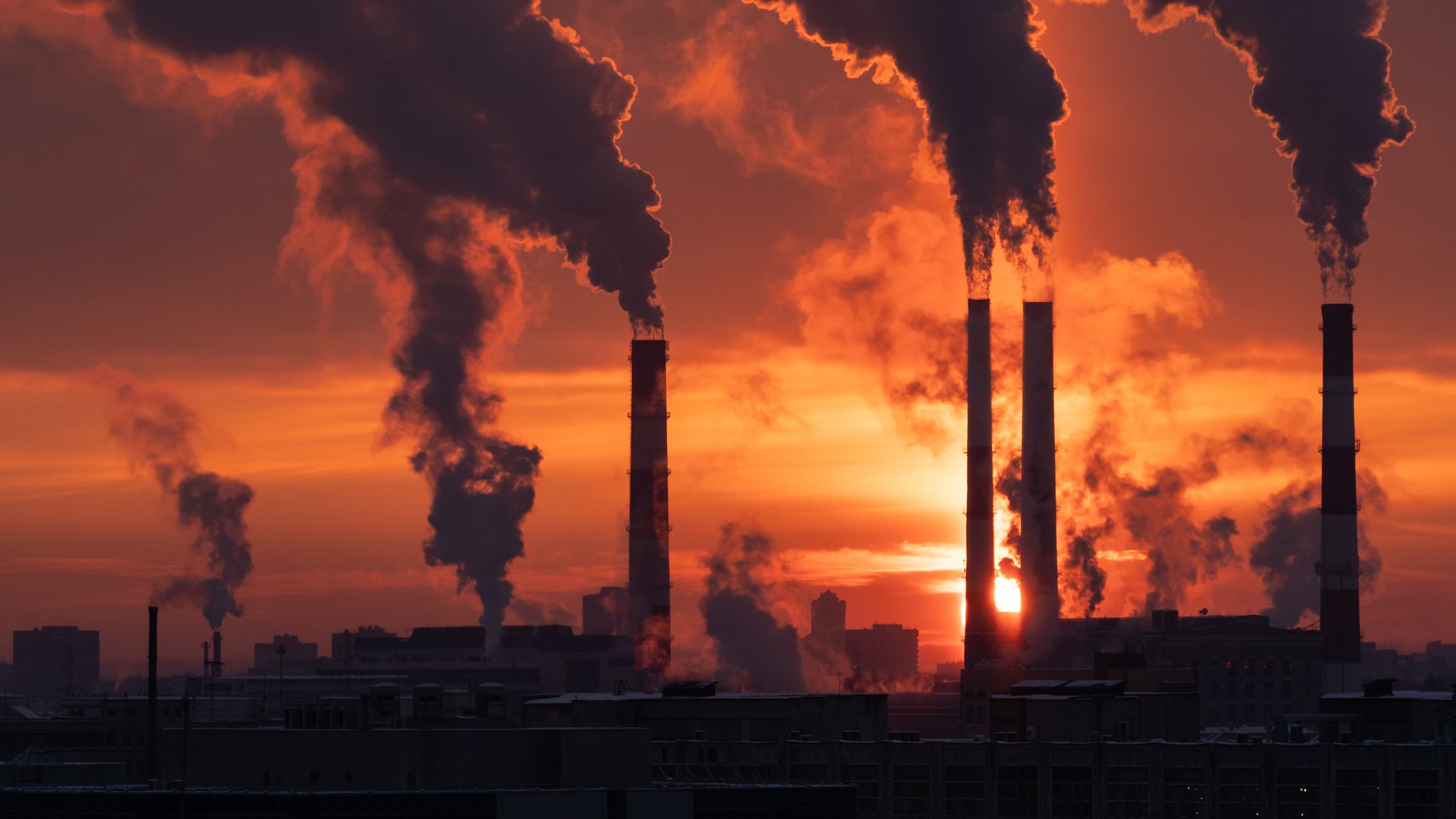 (Symbolbild) Industrieschlöte vor einem Sonnenuntergang