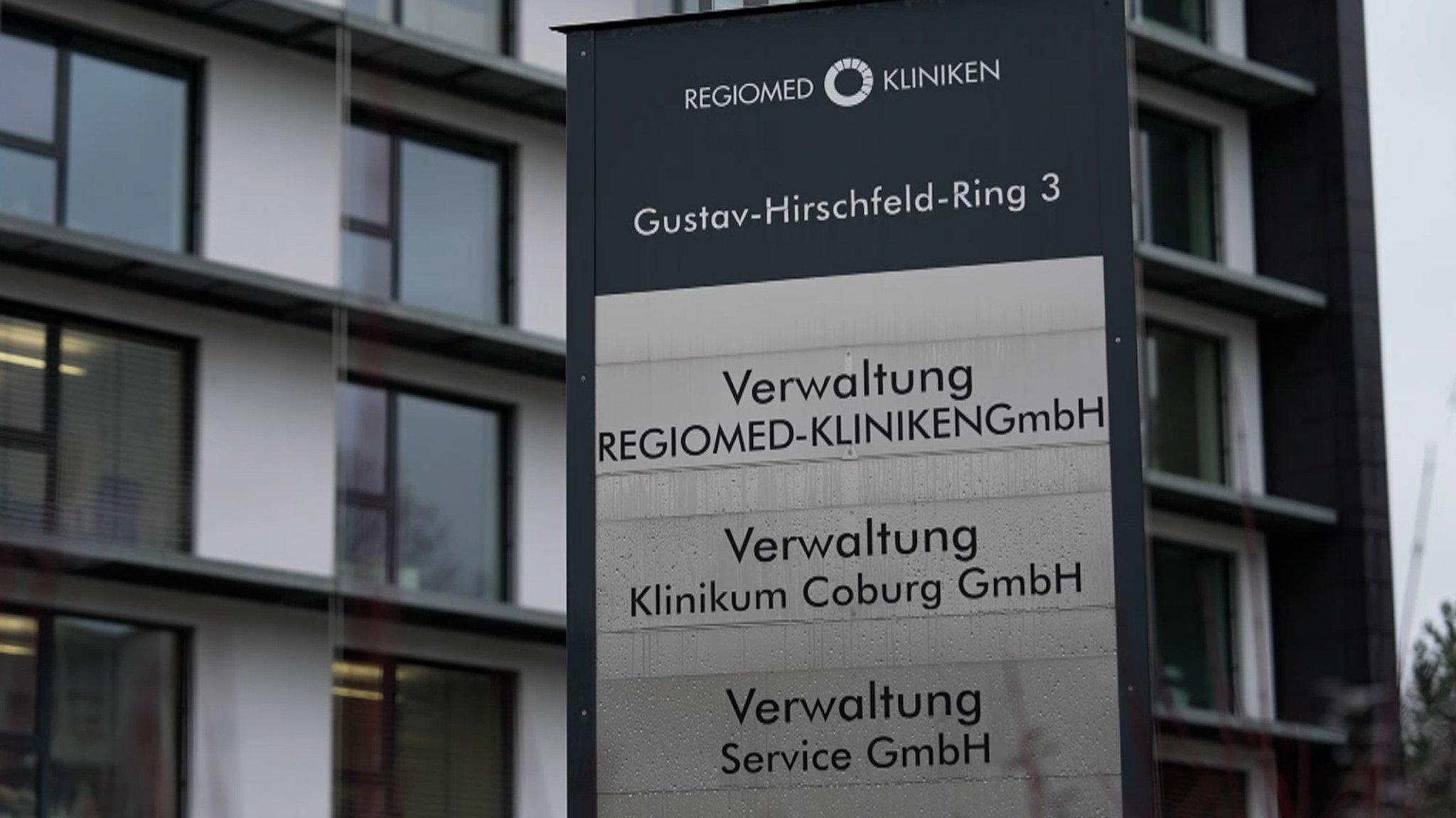 Schild mit der Aufschrift "Verwaltung Regiomed-Kliniken" vor einem Gebäude.