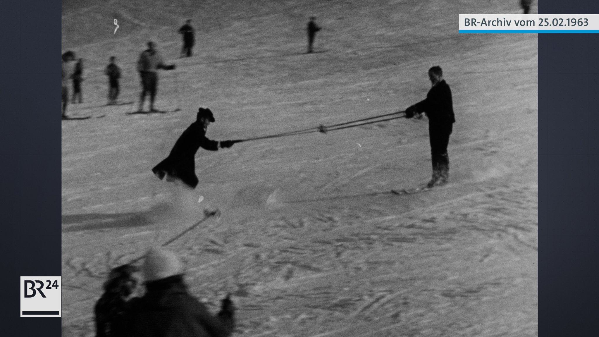 Ein auf Skiern tanzendendes Paar beim Herunterfahren der Piste