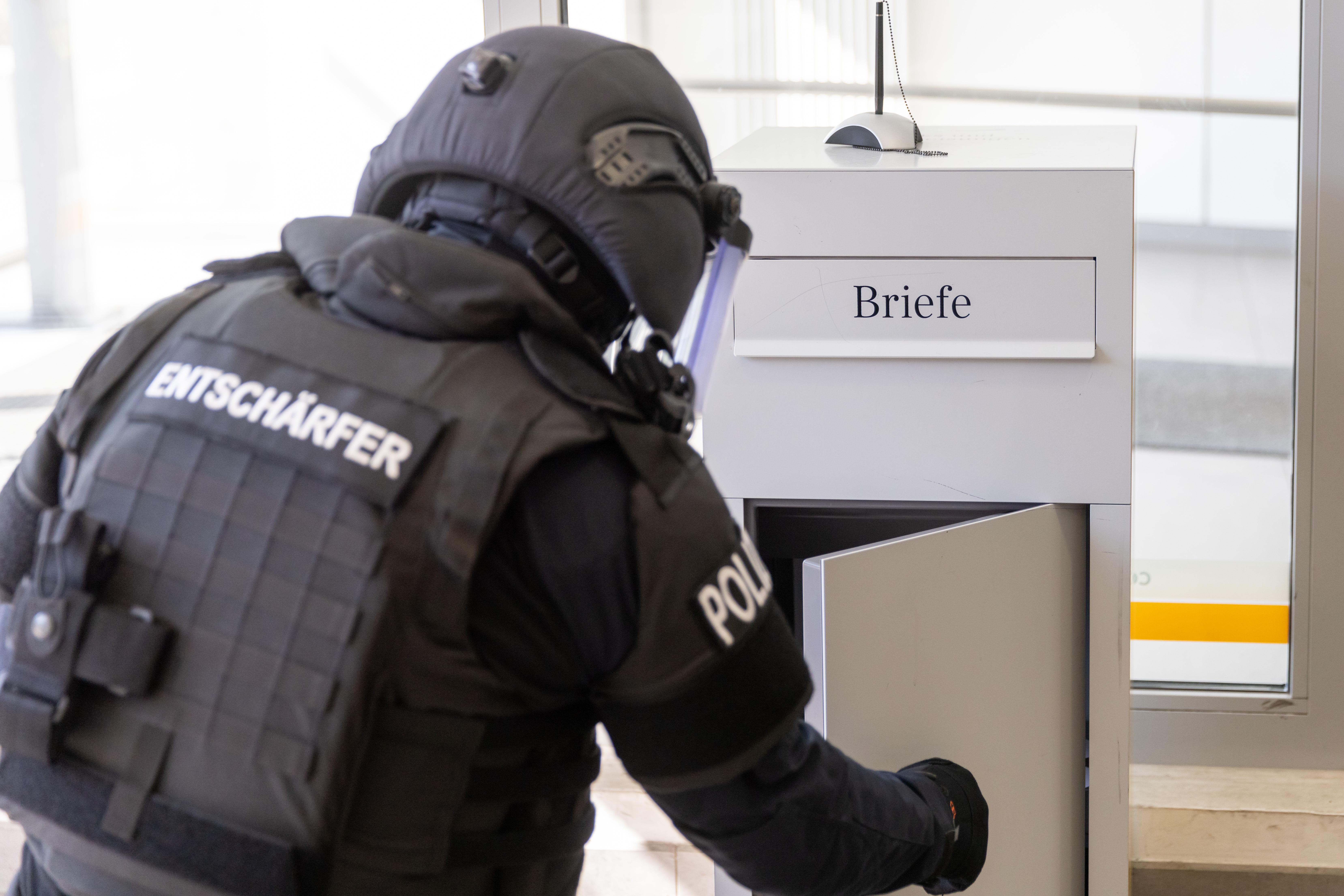 Polizist eines Räumkommandos öffnet einen Briefkasten