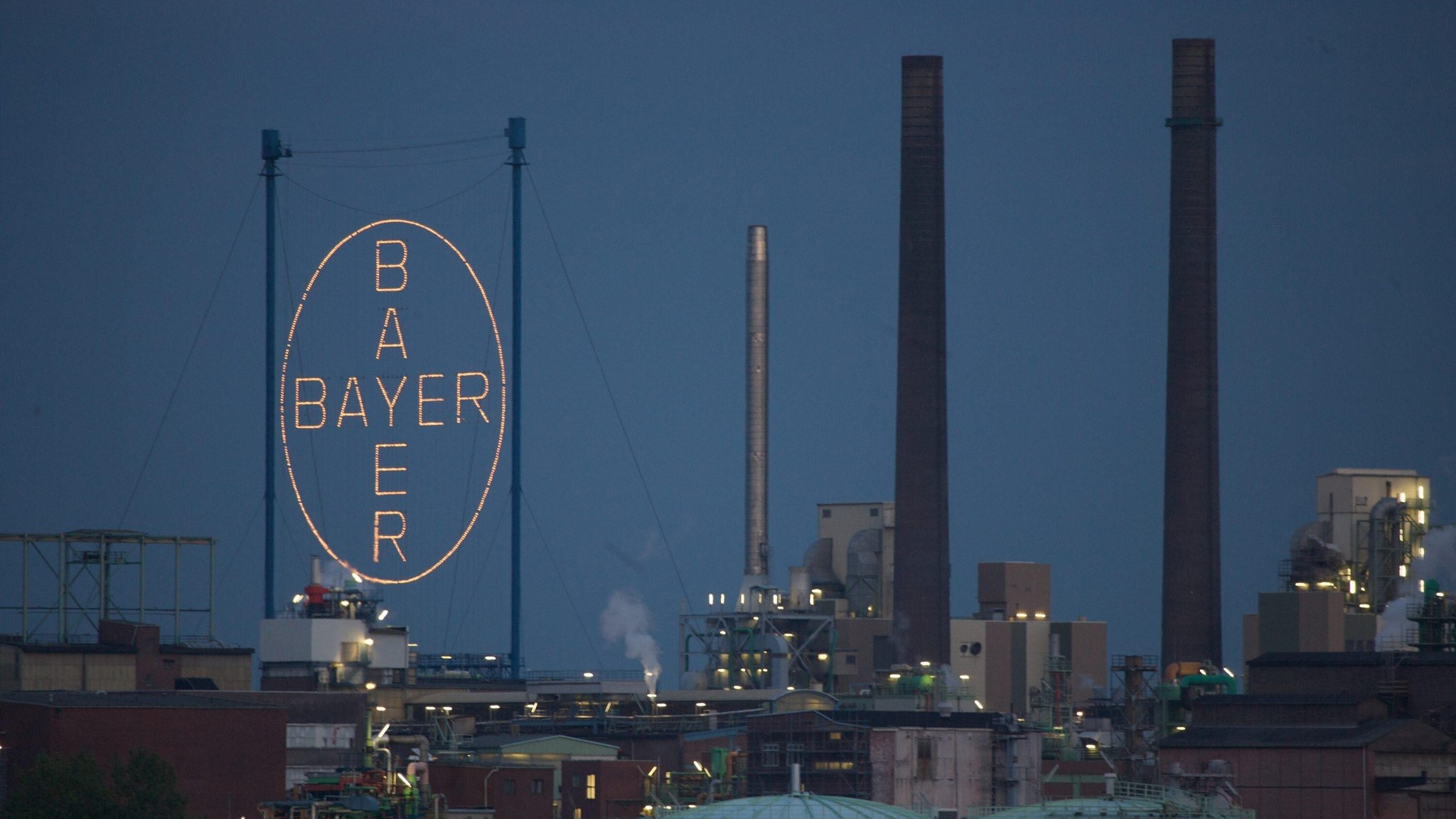 Das beleuchtete Riesen-Logo der Bayer AG über dem Werk in Leverkusen. 