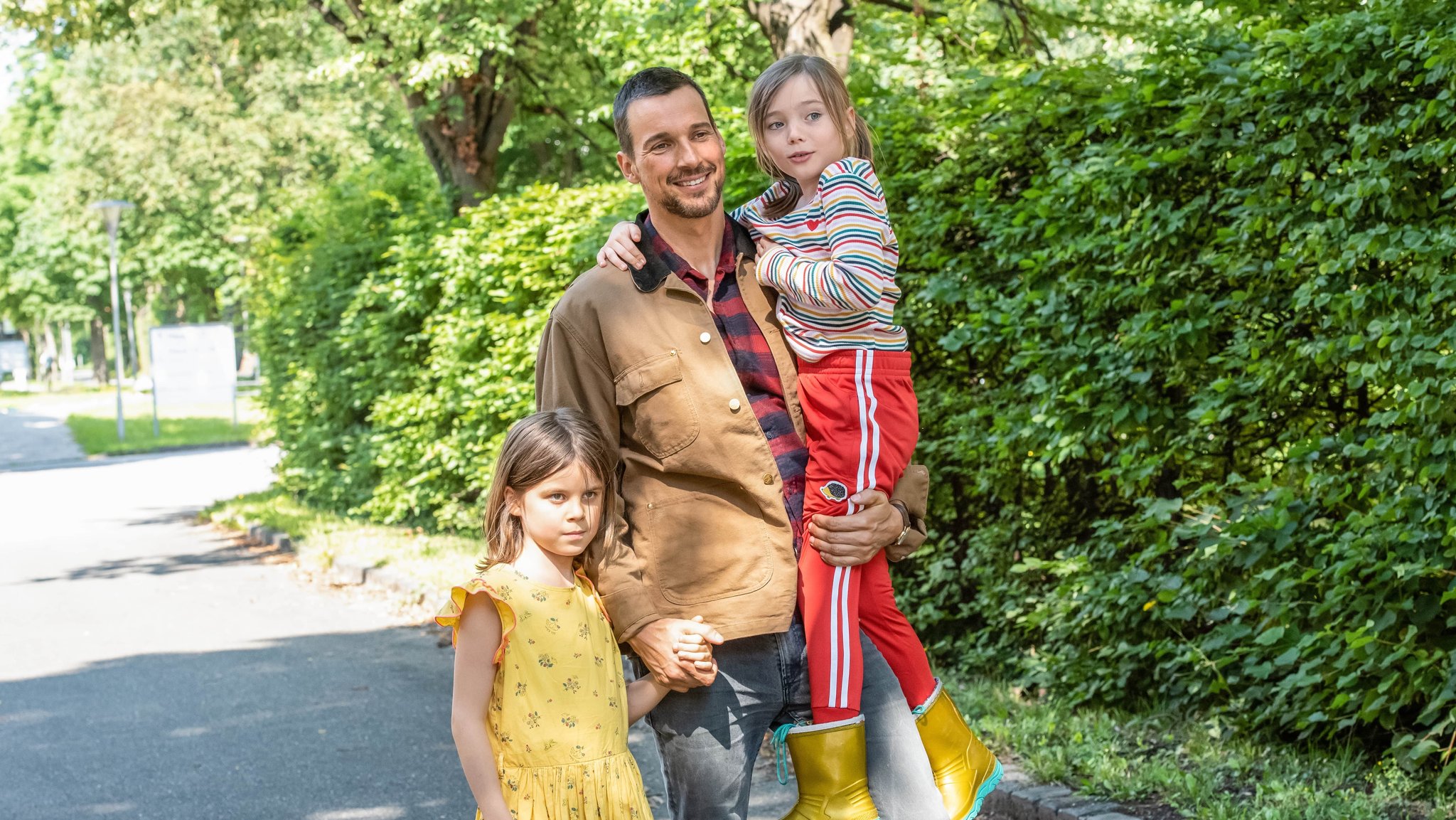 Der Sohn an seiner Hand wäre lieber ein Mädchen: Florian David Fitz (Mitte) als Vater vor Herausforderungen in "Oskars Kleid" (2022).