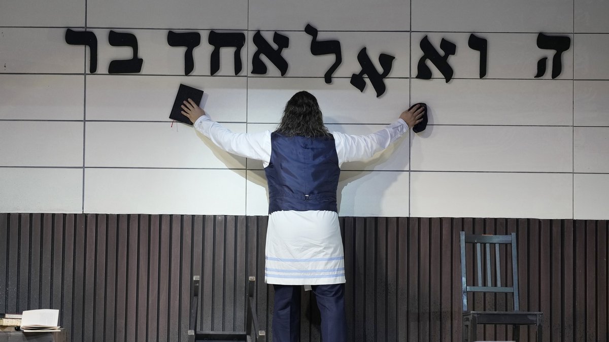 Der Sänger vor einer Wand mit hebräischen Buchstaben