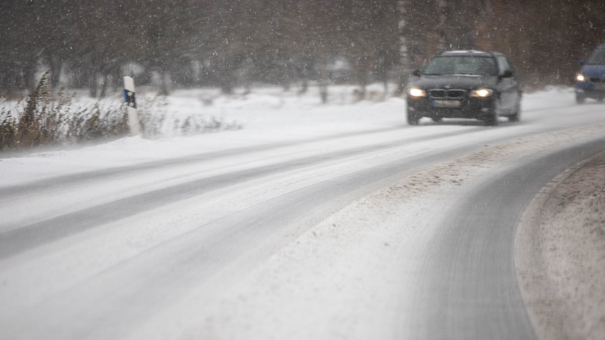 Ein Auto fährt auf einer schneeglatten Straße