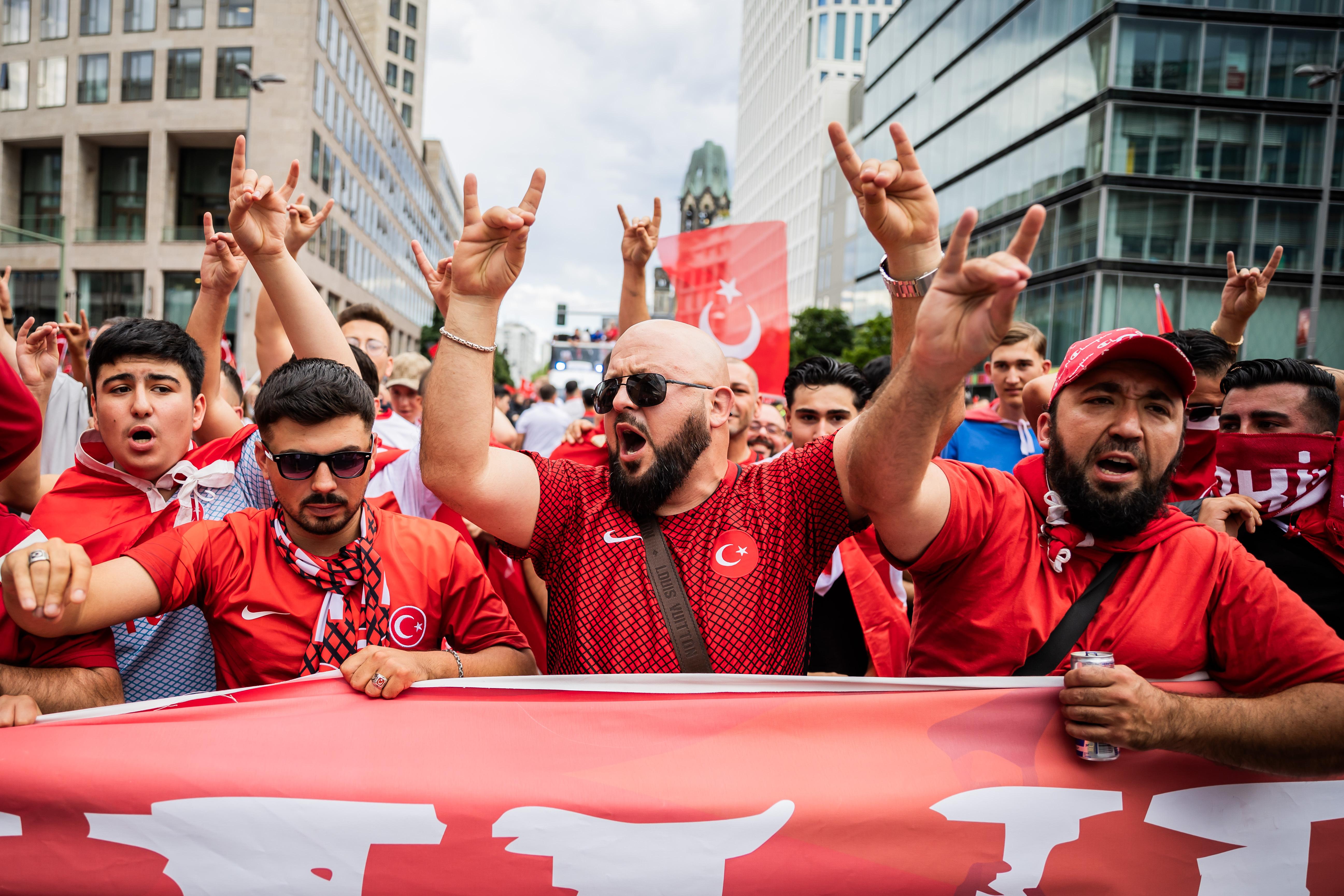 Türkei-Fans zeigen bei einem Fanmarsch Richtung Olympiastadion den "Wolfsgruß", dessen Ursprung einer rechtsextremistischen Bewegung zugeordnet wird.