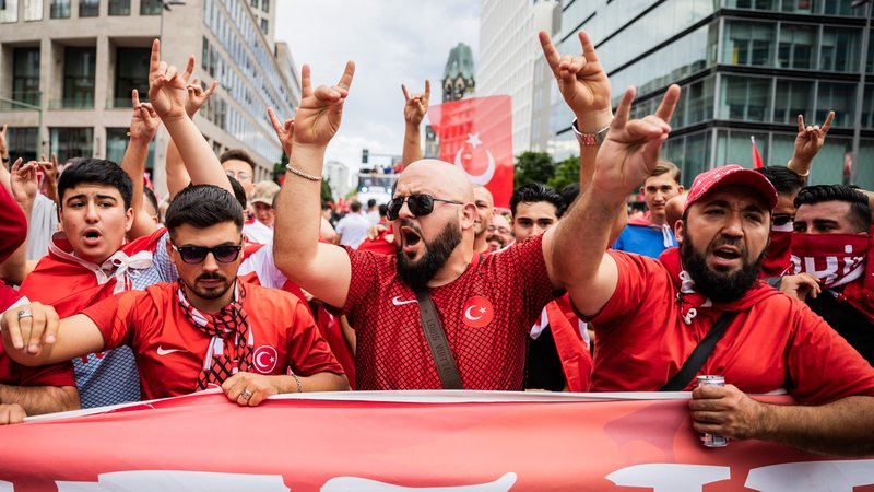Türkei-Fans zeigen bei einem Fanmarsch Richtung Olympiastadion den "Wolfsgruß", dessen Ursprung einer rechtsextremistischen Bewegung zugeordnet wird.