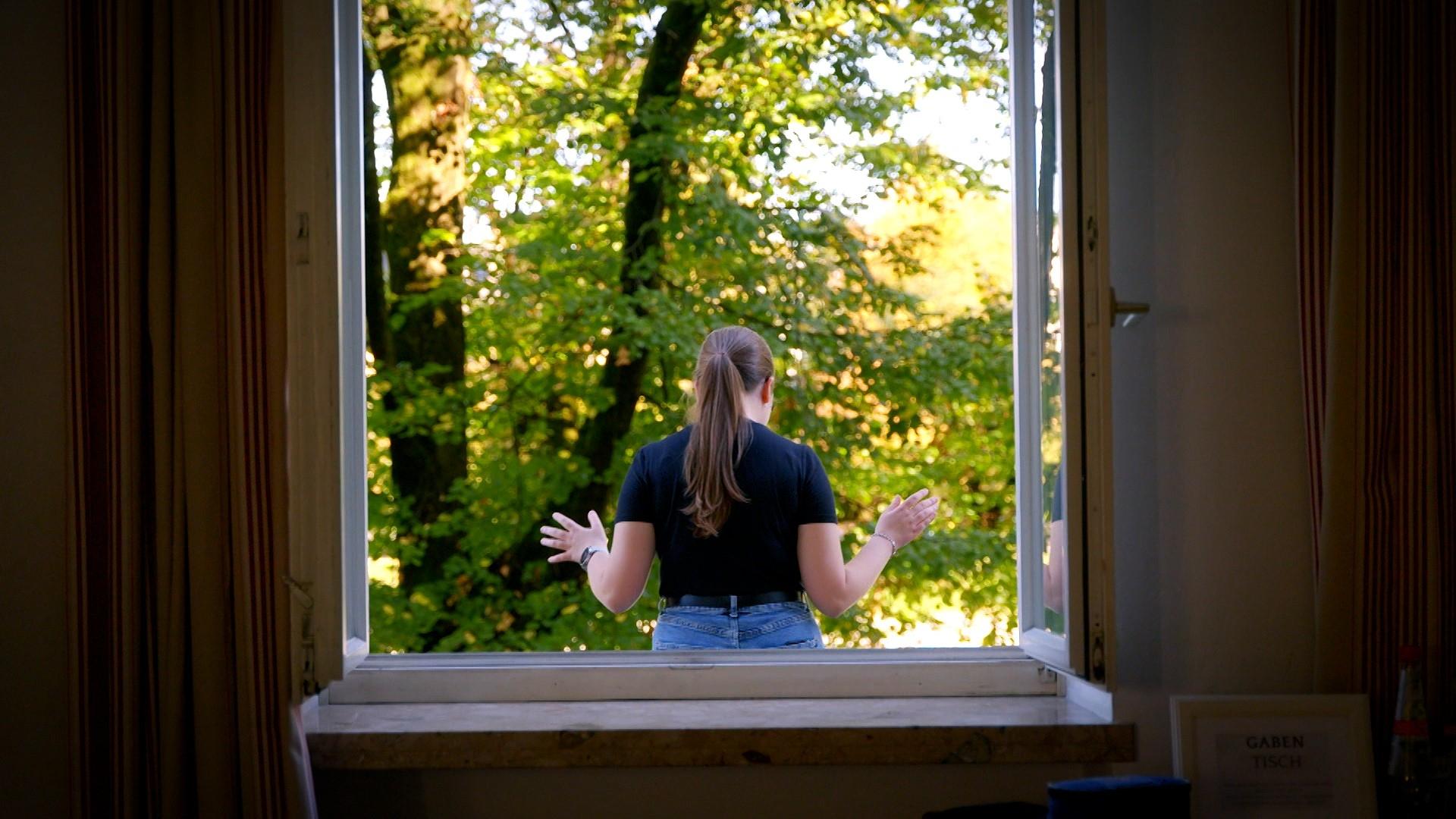 Eine Frau betet auf dem Vordach einer Jüngerschaftsschule
