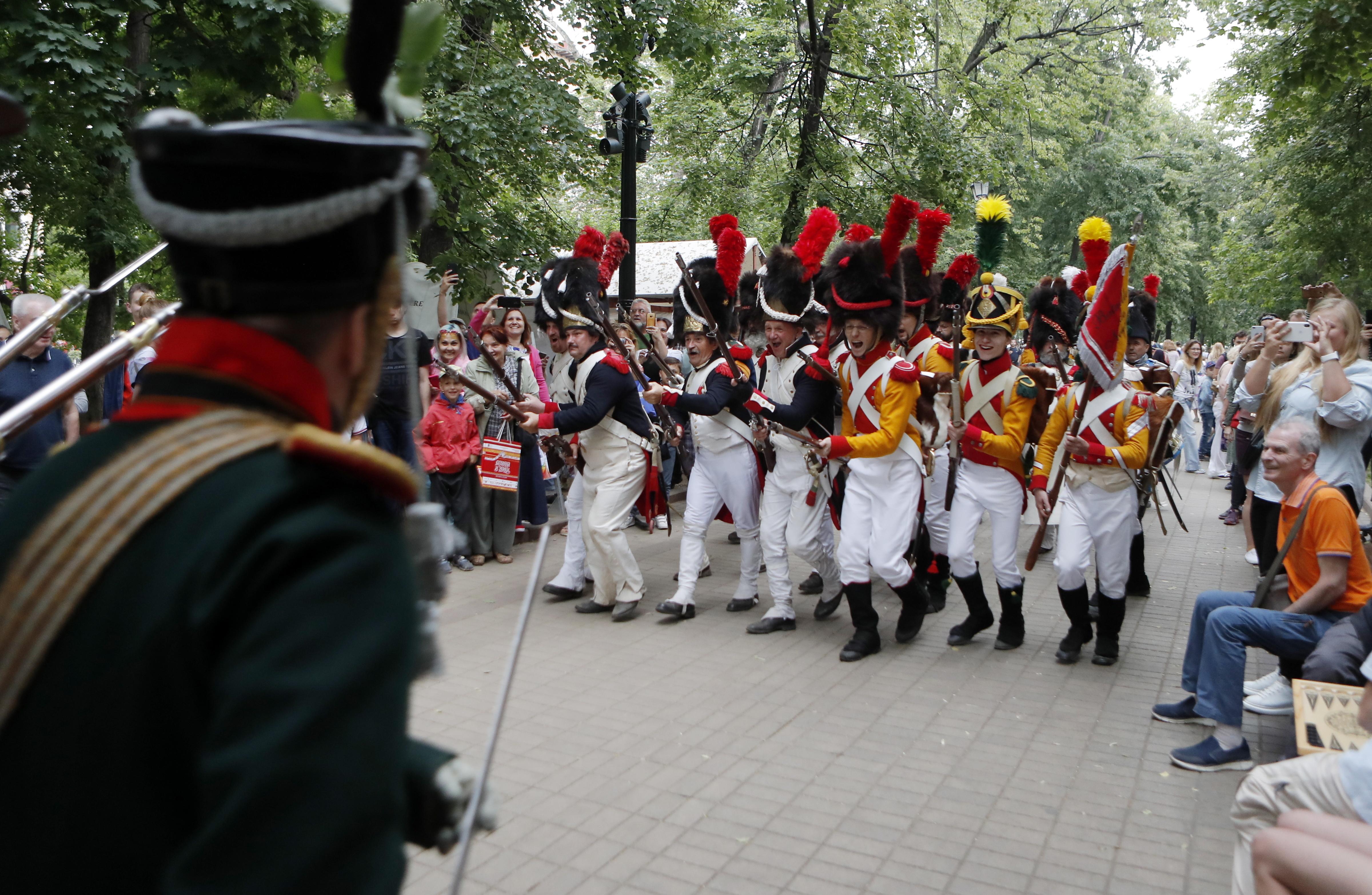 Soldaten in Uniformen von 1814 zücken die Musketen
