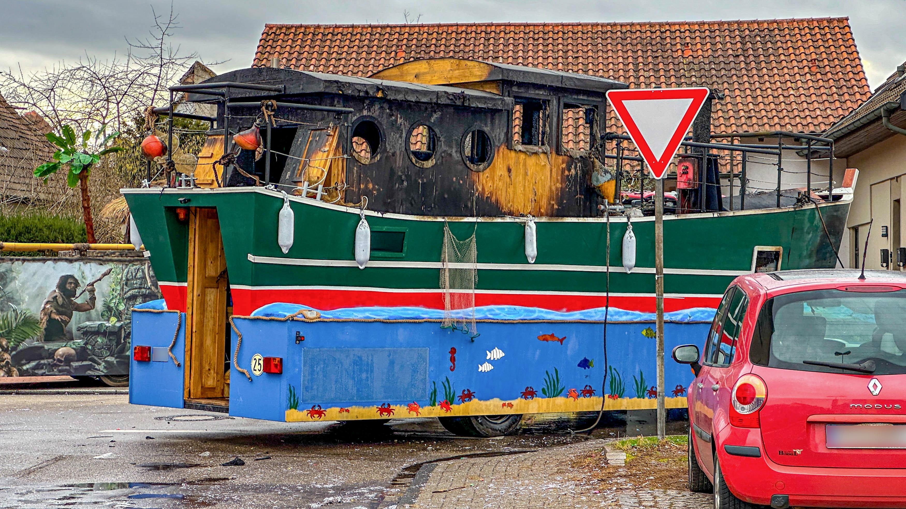 Kehl: Ein Faschingswagen steht ausgebrannt auf einer Straße.