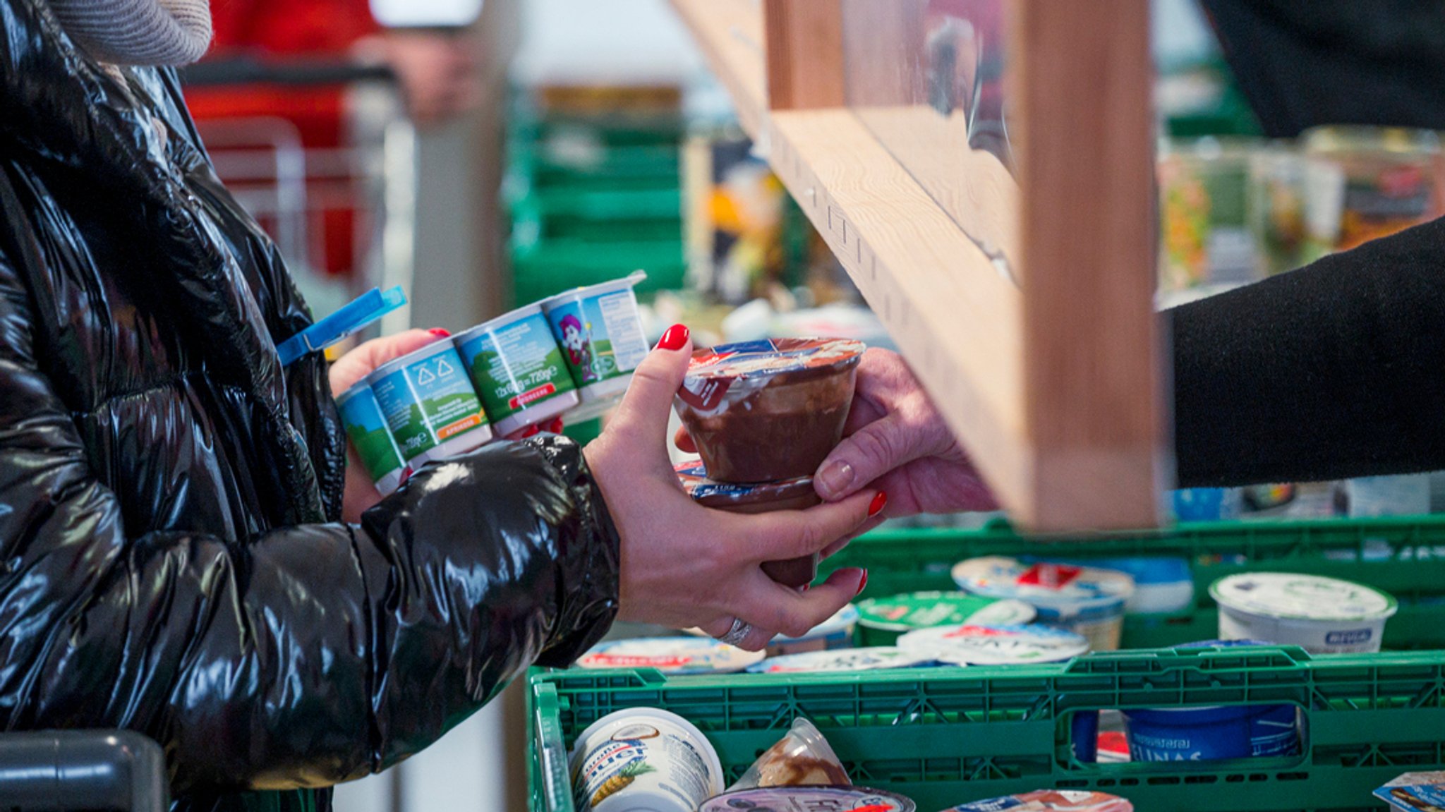 Eine Kundin der Tafel Coburg kauft Joghurt und Pudding ein. 