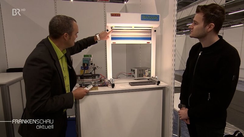 Ein Mann stellt auf der Erfindermesse iENA einen selbst reinigenden Rollo vor. | Bild: BR Ein Mann stellt auf der Erfindermesse iENA einen selbst reinigenden Rollo vor.