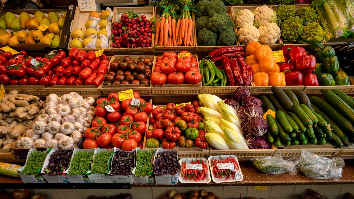 ARCHIV (26.03.2024): Auslage in einer Bauernmarkthalle mit Obst, Salat und Gemüse