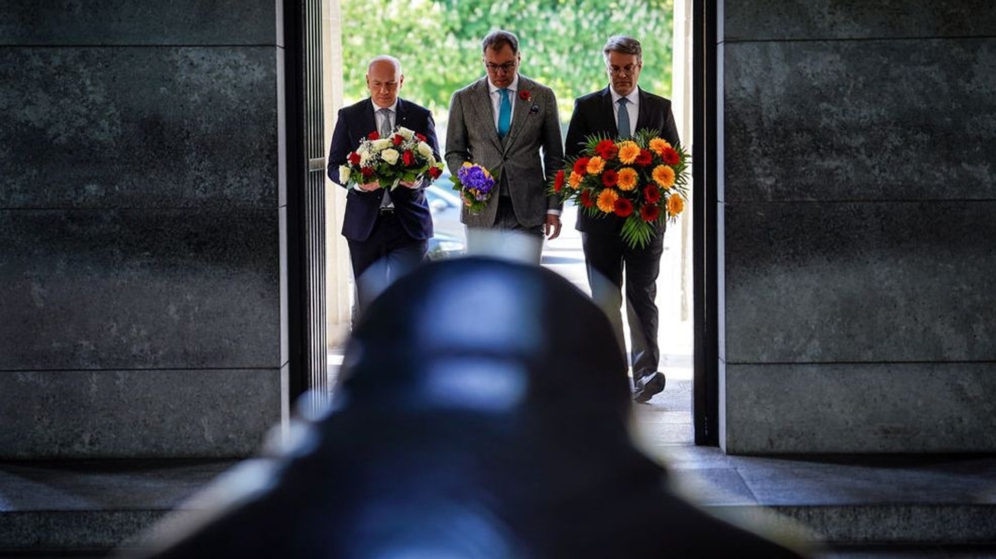 08.05.2023, Berlin: Kai Wegner (l-r, CDU), Berlins Regierender Bürgermeister, Oleksii Makeiev, Botschafter der Ukraine in Deutschland, und Tobias Lindner (Bündnis 90/Die Grünen), Staatsminister im Auswärtigen Amt, legen in Erinnerung an das Ende des 2.Weltkriegs Blumen in der Neuen Wache nieder. Foto: Kay Nietfeld/dpa +++ dpa-Bildfunk +++