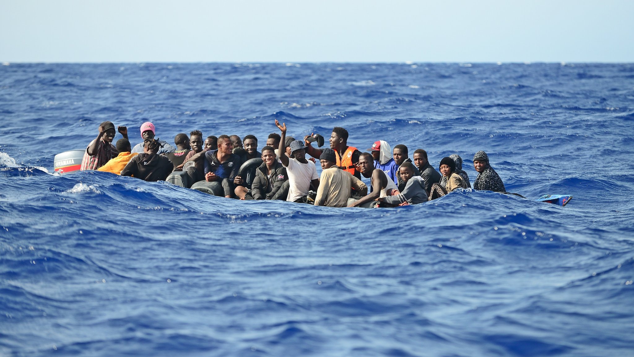 Symbolbild: Migration über das zentrale Mittelmeer. Ein Holzboot mit etwa 30 Menschen versucht bei hohen Wellengang die gefährliche Überfahrt nach Italien. Oft geraten diese labilen und überfüllten Boote in Seenot.