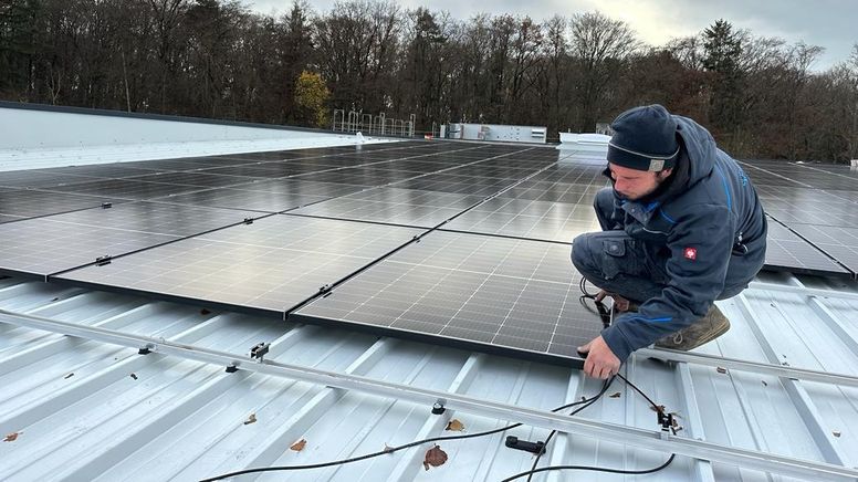 Arbeiter, der auf dem Dach eine PV-Anlage montiert.  | Bild:BR / Daniela Olivares