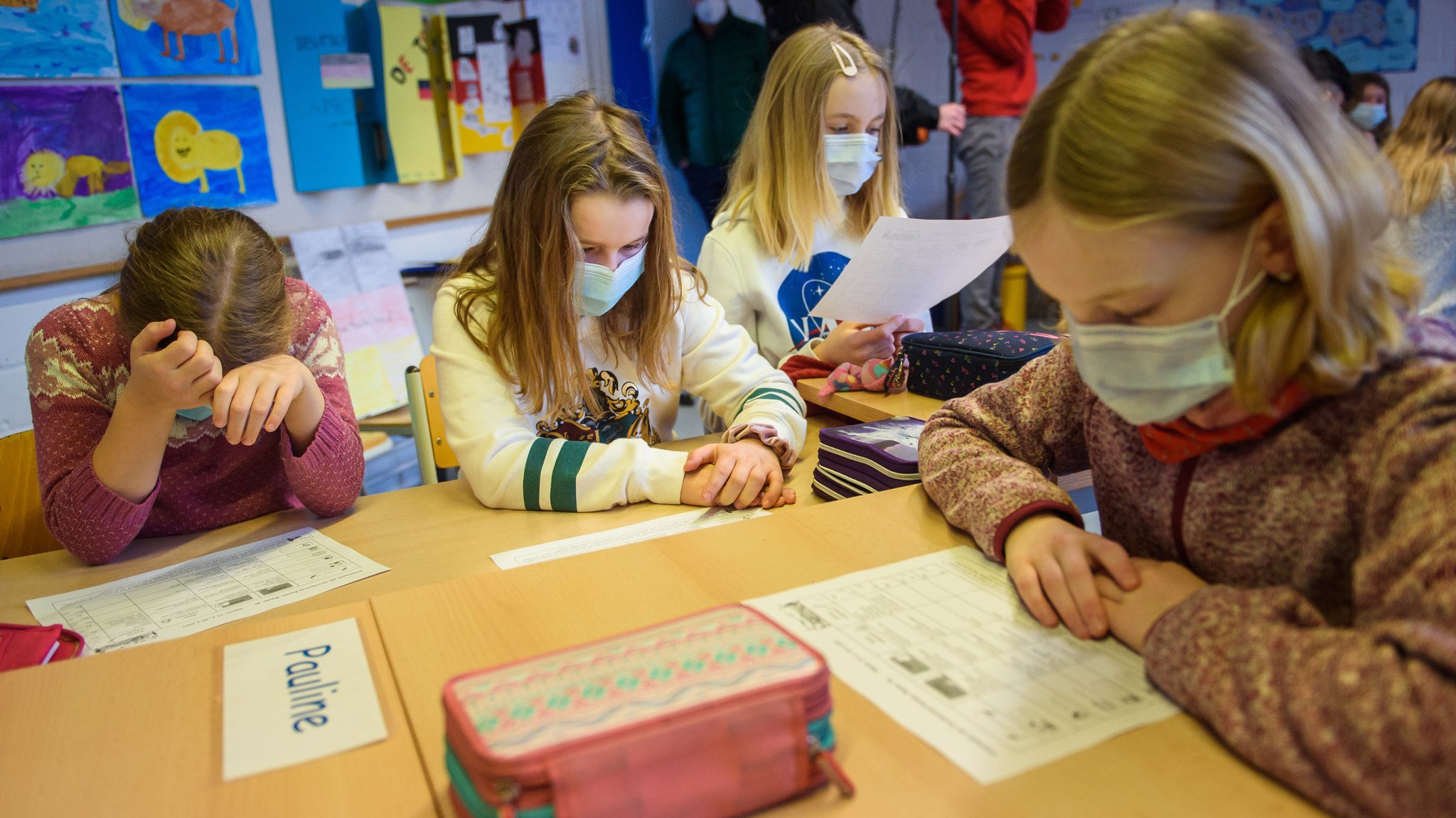 Schülerinnen einer 4. Klasse lesen im Unterricht einer Grundschule gemeinsam eine Aufgabe.