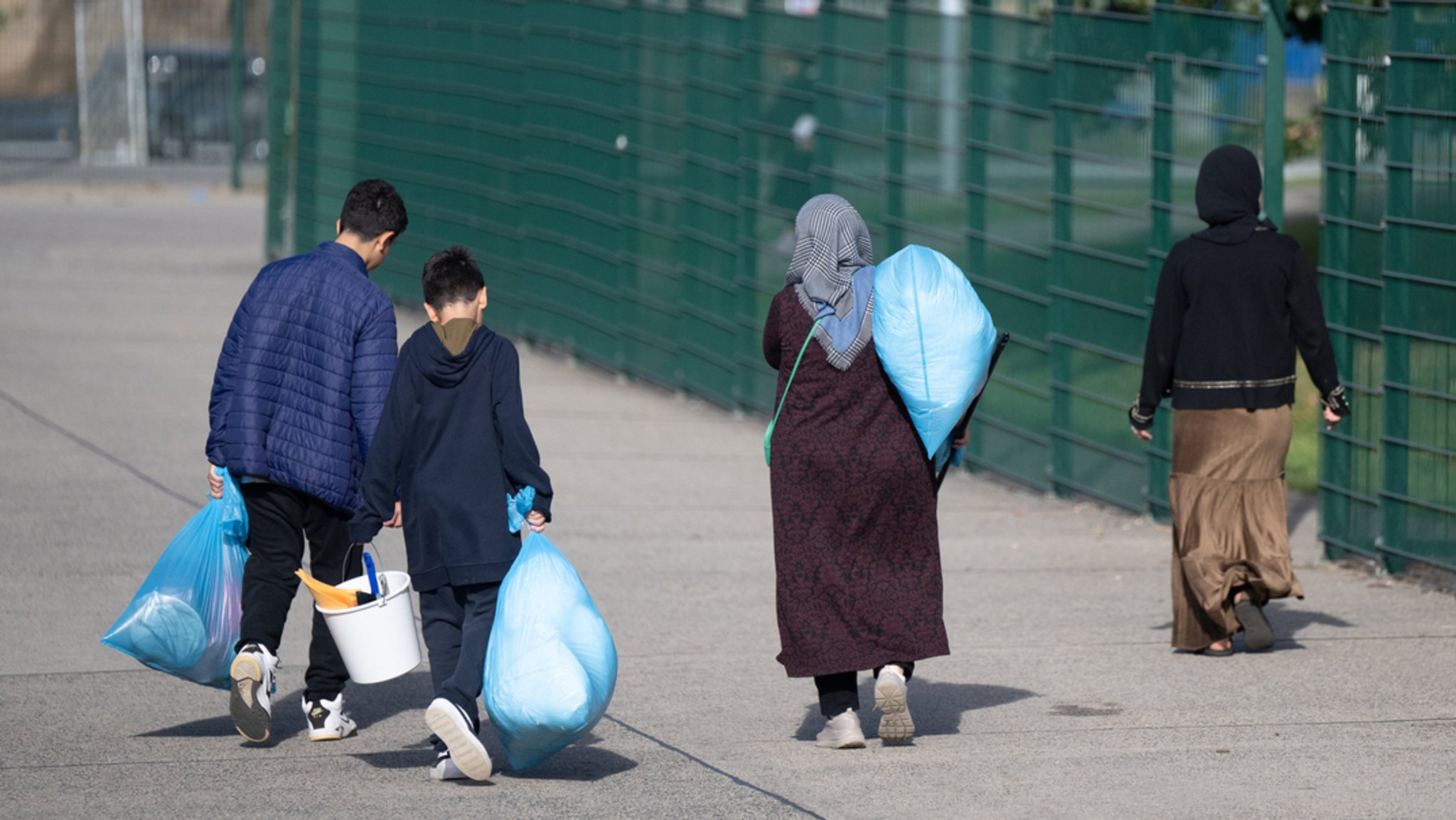 In Plastiksäcken tragen neu angekommene Flüchtlinge ihre Habseligkeiten in der hessischen Erstaufnahmeeinrichtung in Gießen (Archivbild).