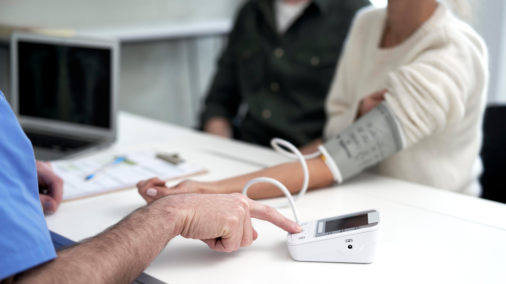 Ein Arzt misst den Blutdruck einer Patientin. Derzeit gibt es in Bayern so viele Ärztinnen und Ärzte wie noch nie. Dennoch warnen Berufsverbände vor einem Ärztemangel.