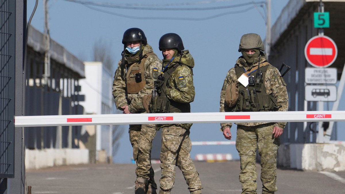 Ukraine, Novotroitske: Ukrainische Grenzbeamte stehen an einem Kontrollpunkt zwischen dem von den von Russland unterstützten Separatisten kontrollierten Gebiet und dem von den ukrainischen Streitkräften kontrollierten Gebiet in der Ostukraine.
