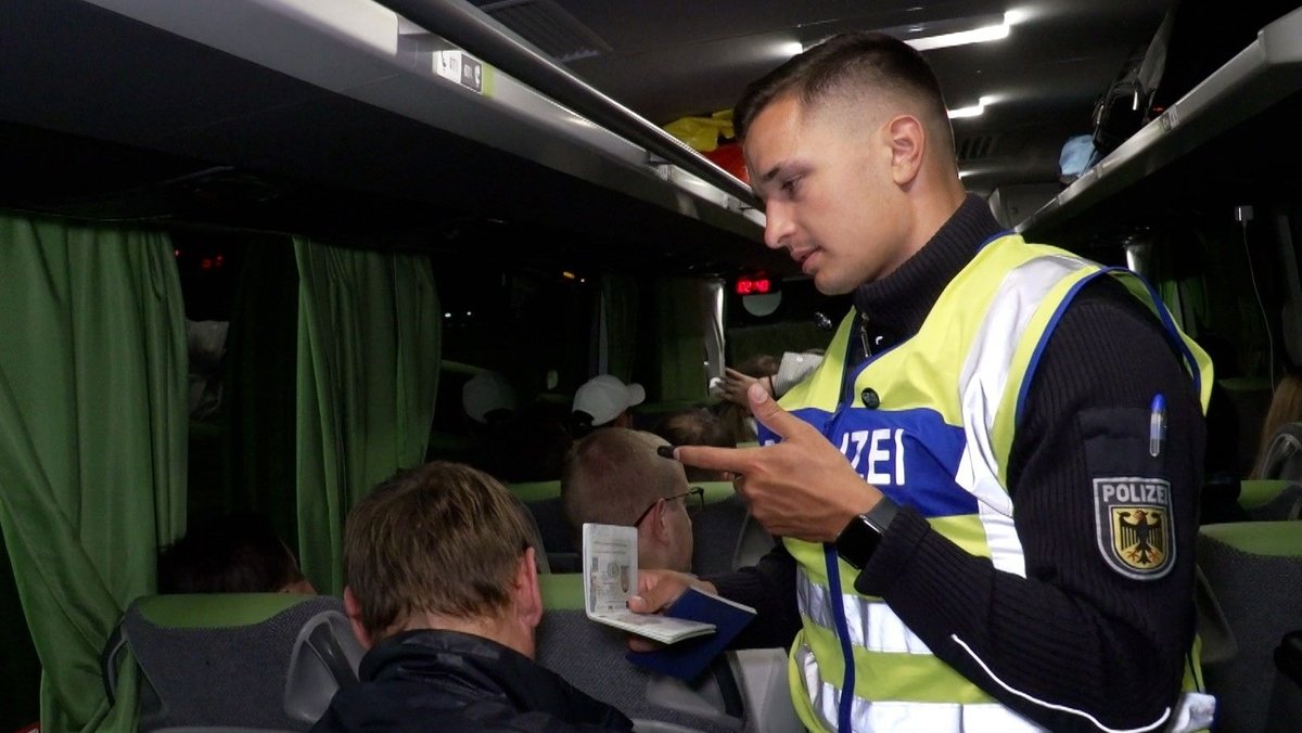 Bundespolizist bei Ausweiskontrolle in einem Bus
