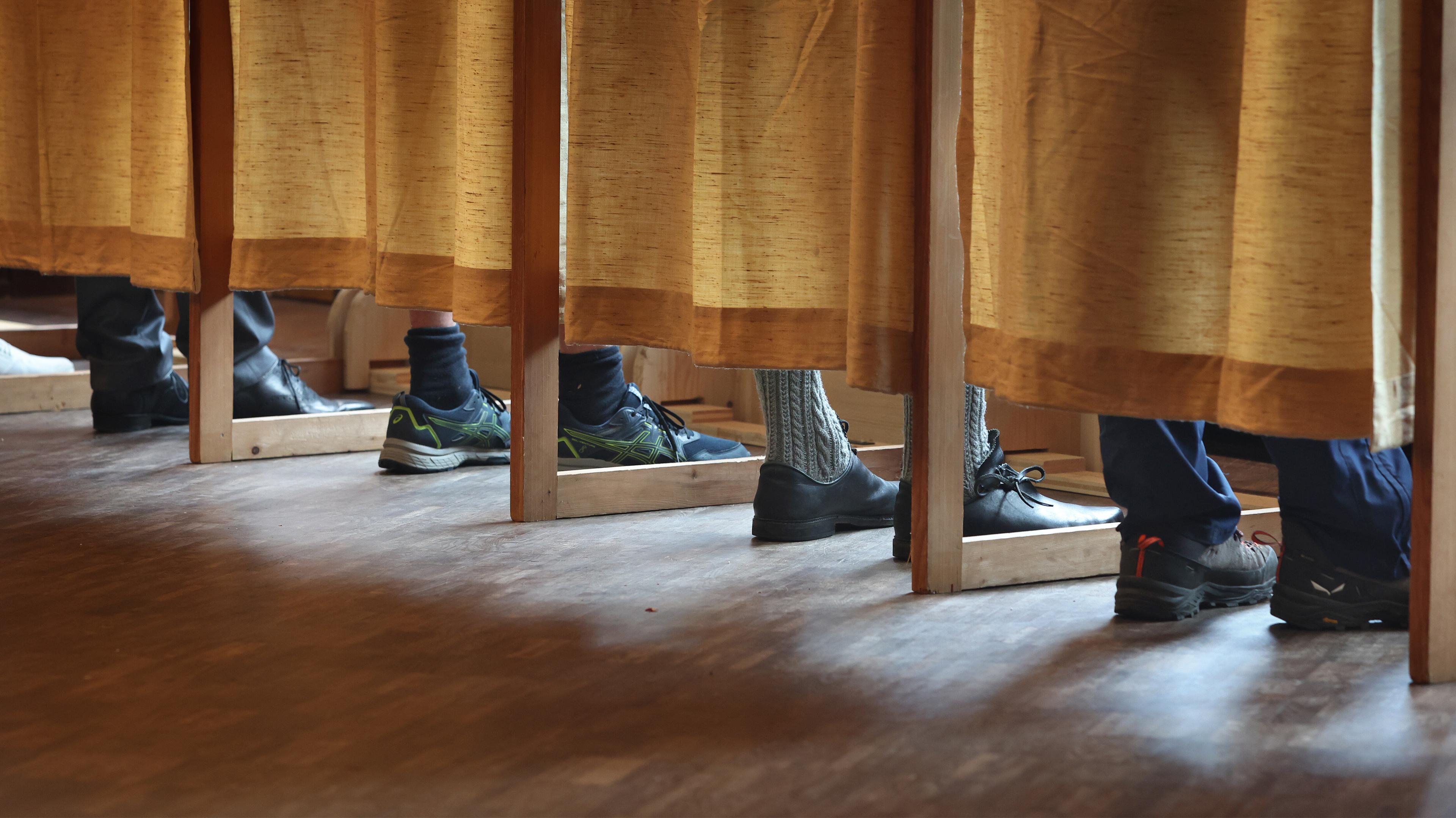 Wählerinnen und Wähler stehen in einem Wahllokal in einer Wahlkabine. In Bayern findet am Sonntag die Wahl zum 19. Bayerischen Landtag statt.