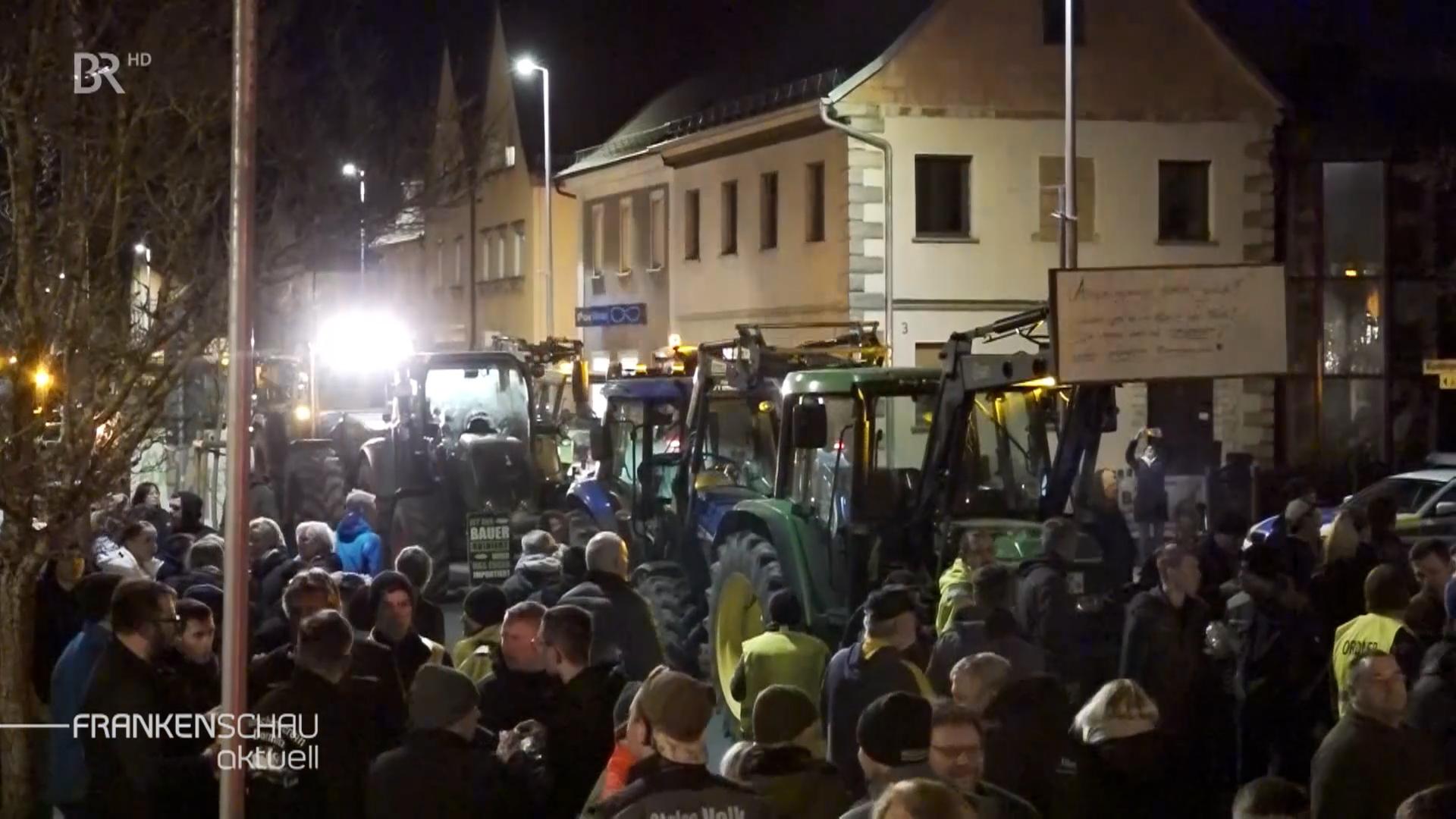 Menschen und Traktoren auf einer Demo.