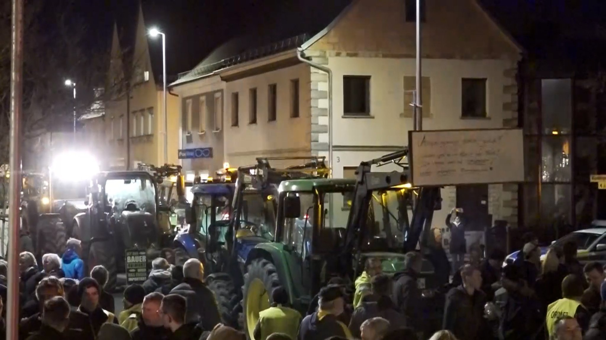 Menschen und Traktoren auf einer Demo.