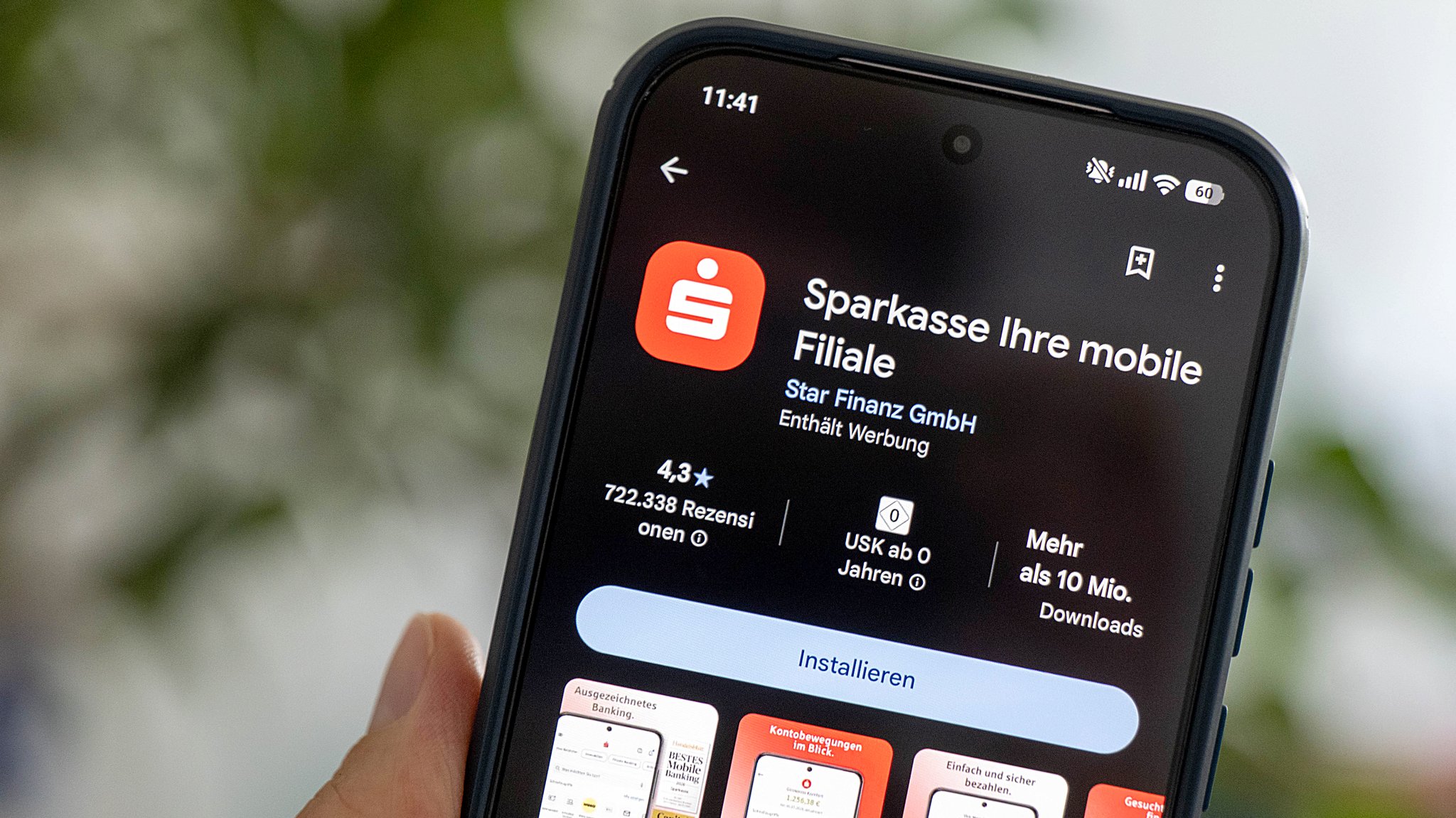 Eine Hand hält ein Smartphone auf dem die Sparkassen-App im App-Store zu sehen ist.