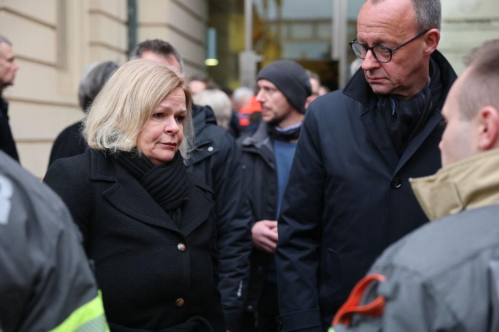 21.12.2024, Sachsen-Anhalt, Magdeburg: Bundesinnenministerin Nancy Faeser (l, SPD) und Friedrich Merz, CDU Bundesvorsitzender und CDUCSU Fraktionsvorsitzender im Bundestag und Unions-Kanzlerkandidat, besuchen den Ort der tödlichen Attacke auf dem Weihnachtsmarkt und bedanken sich bei der Feuerwehr. Am Vorbend ist auf dem Weihnachtsmarkt in Magdeburg ein Autofahrer in eine Menschengruppe gefahren. Es gab mehrere Tote und Verletzte. Foto: Jan Woitas/dpa +++ dpa-Bildfunk +++