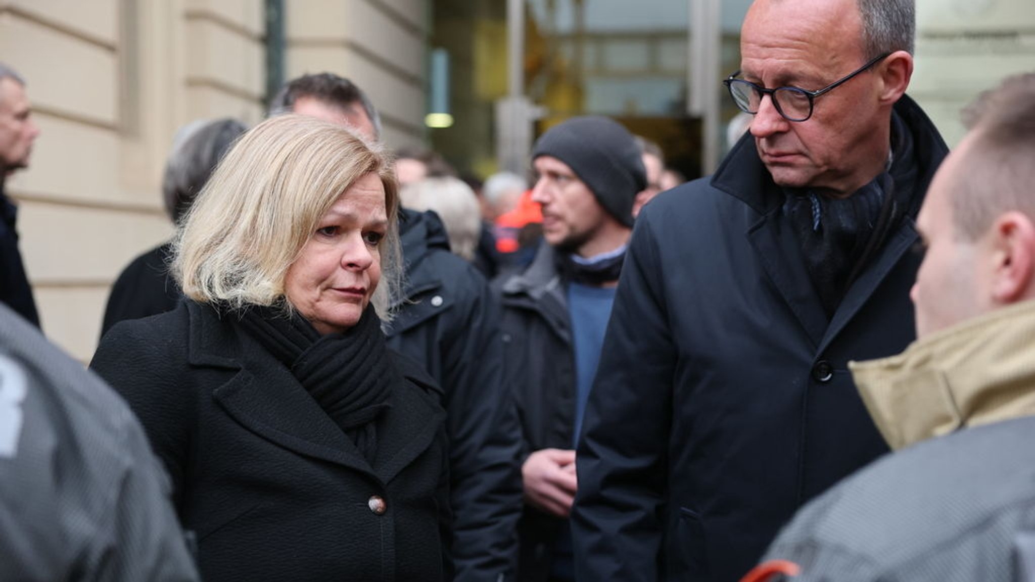 21.12.2024, Sachsen-Anhalt, Magdeburg: Bundesinnenministerin Nancy Faeser (l, SPD) und Friedrich Merz, CDU Bundesvorsitzender und CDUCSU Fraktionsvorsitzender im Bundestag und Unions-Kanzlerkandidat, besuchen den Ort der tödlichen Attacke auf dem Weihnachtsmarkt und bedanken sich bei der Feuerwehr. Am Vorbend ist auf dem Weihnachtsmarkt in Magdeburg ein Autofahrer in eine Menschengruppe gefahren. Es gab mehrere Tote und Verletzte. Foto: Jan Woitas/dpa +++ dpa-Bildfunk +++