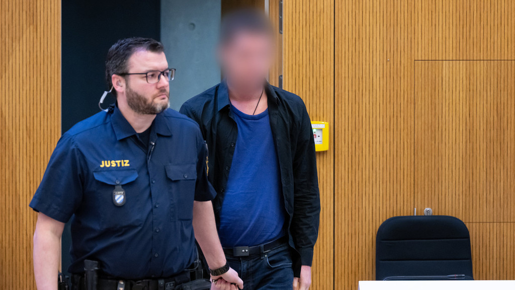 Einer von zwei wegen Mordes angeklagten Männern (r) wird am 6. März vor Beginn der Verhandlung in den Hochsicherheitsgerichtssaal vom Landgericht München II geführt.