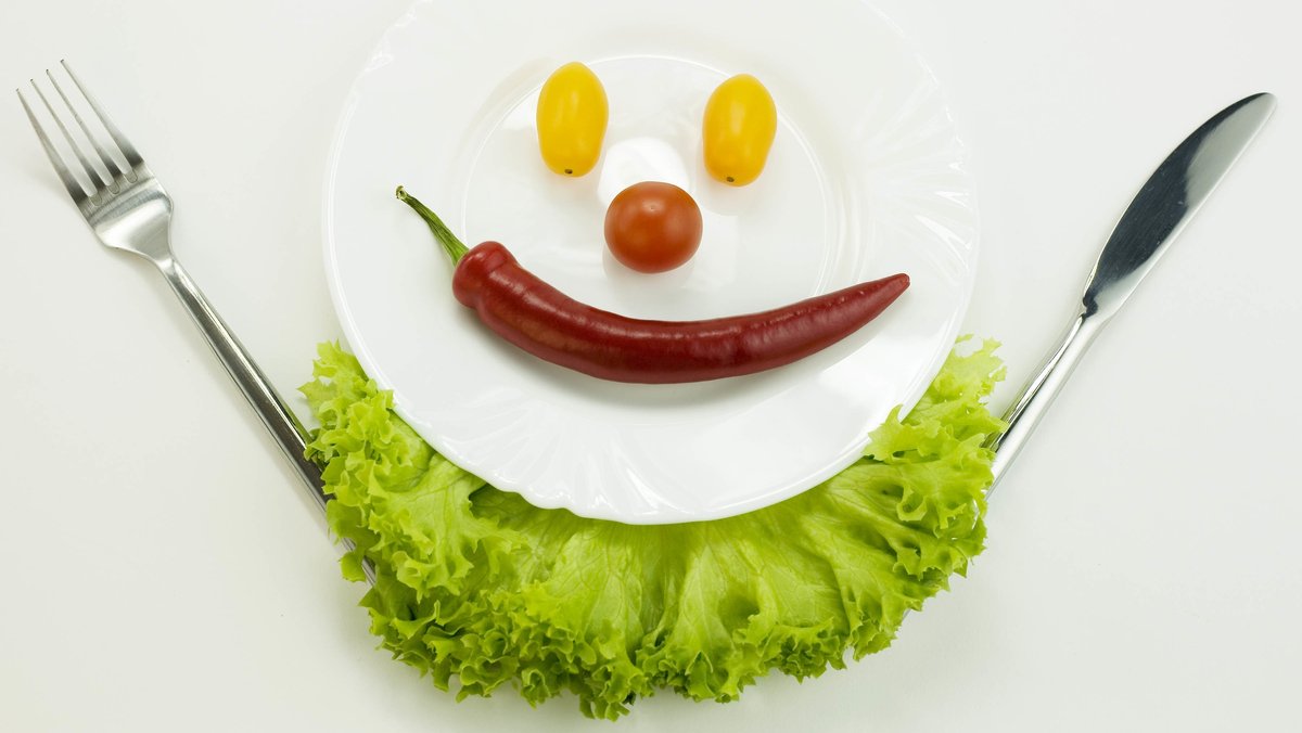 Ein Gesicht aus Gemüse ist auf einem Teller angerichtet: Zukünftig werden wir viel mehr Gemüse essen, wenn alle Menschen satt werden sollen.