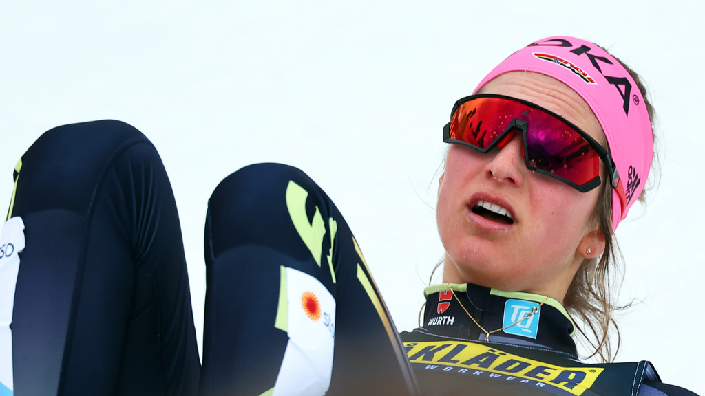 Langläuferin Laura Gimmler liegt erschöpft im Ziel.