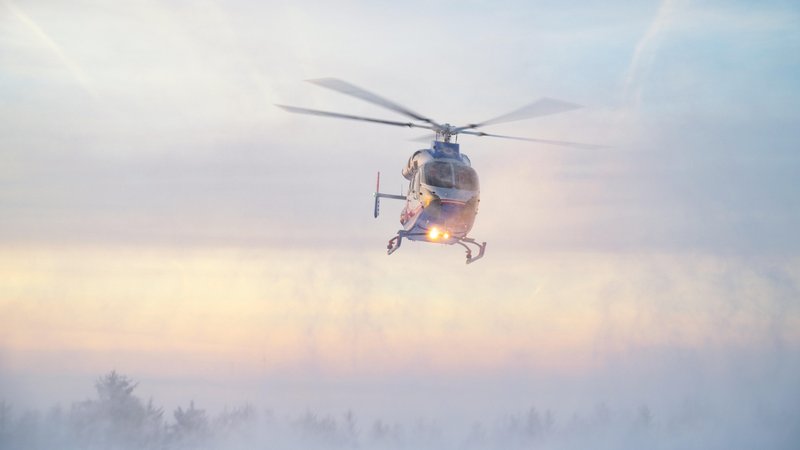 Ein Rettungshubschrauber fliegt in den Bergen bei Schneetreiben herum. | Bild: picture alliance / Zoonar | Berit Kessler Ein Rettungshubschrauber fliegt in den Bergen bei Schneetreiben herum.