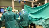 Ärzte und Pflegekräfte in grüner OP-Kleidung operieren einen Patienten. | Bild:BR24
