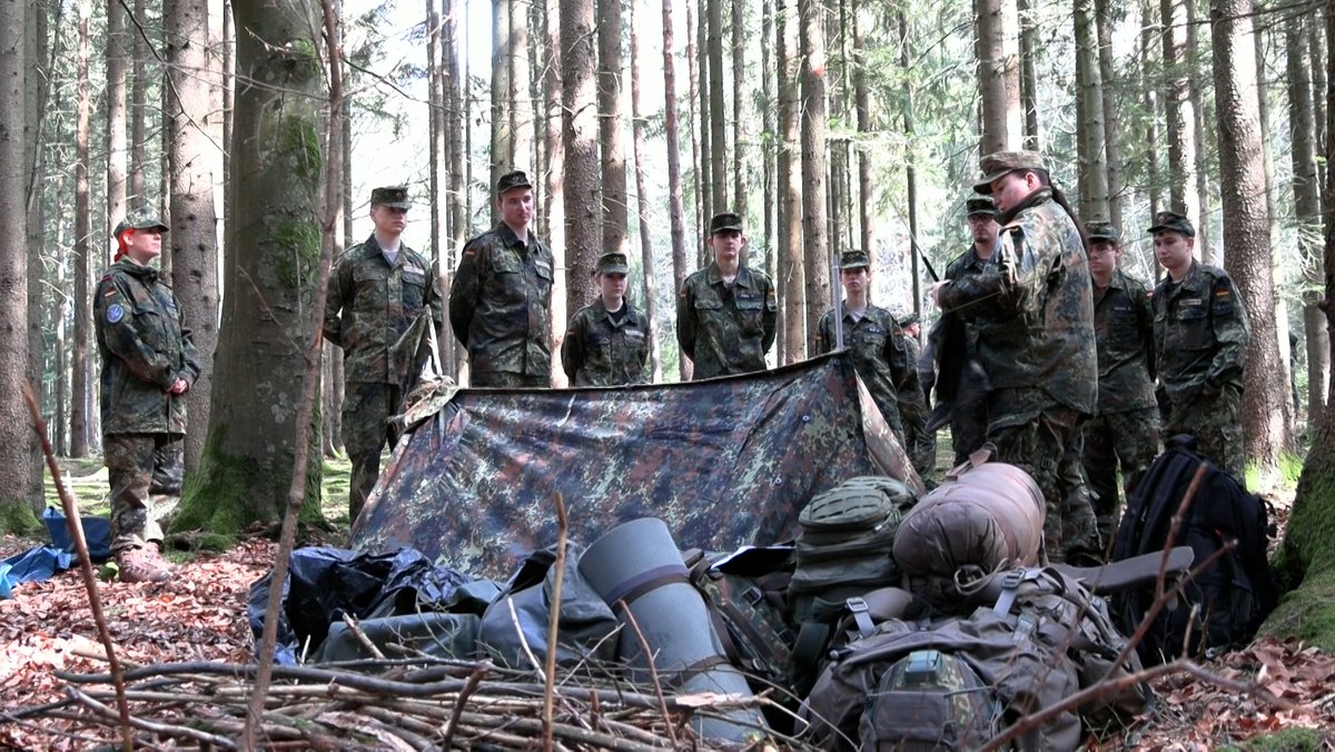 Camp-Teilnehmer in Bundeswehruniform im Wald.