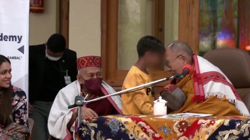 Der Dalai Lama und ein Junge berühren sich mit der Stirn.