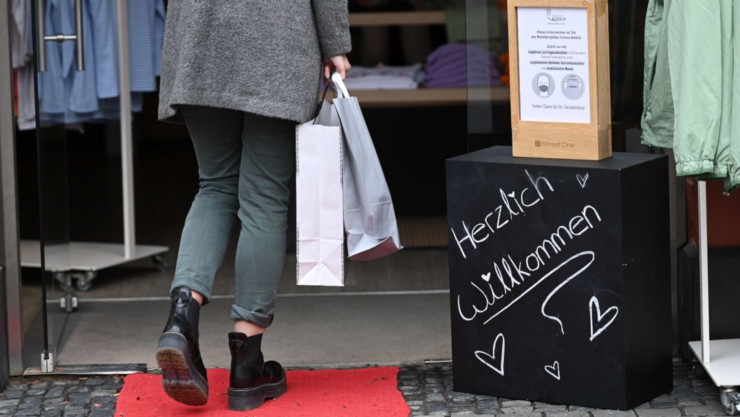 Eine Frau mit Einkaufstaschen betritt ein Modegeschäft | Bild: dpa-Bildfunk/Uwe Zucchi Eine Frau mit Einkaufstaschen betritt ein Modegeschäft