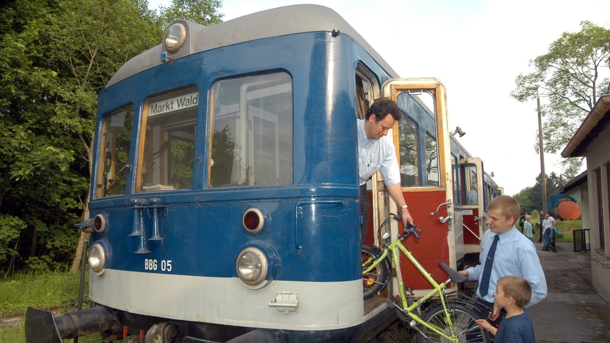 29. Mai 2003: Zwei Mitarbeiter der Staudenbahn helfen in Markt Wald im Kreis Unterallgäu einem Jungen beim Verladen seines Fahrrades in einen Triebwagen. 