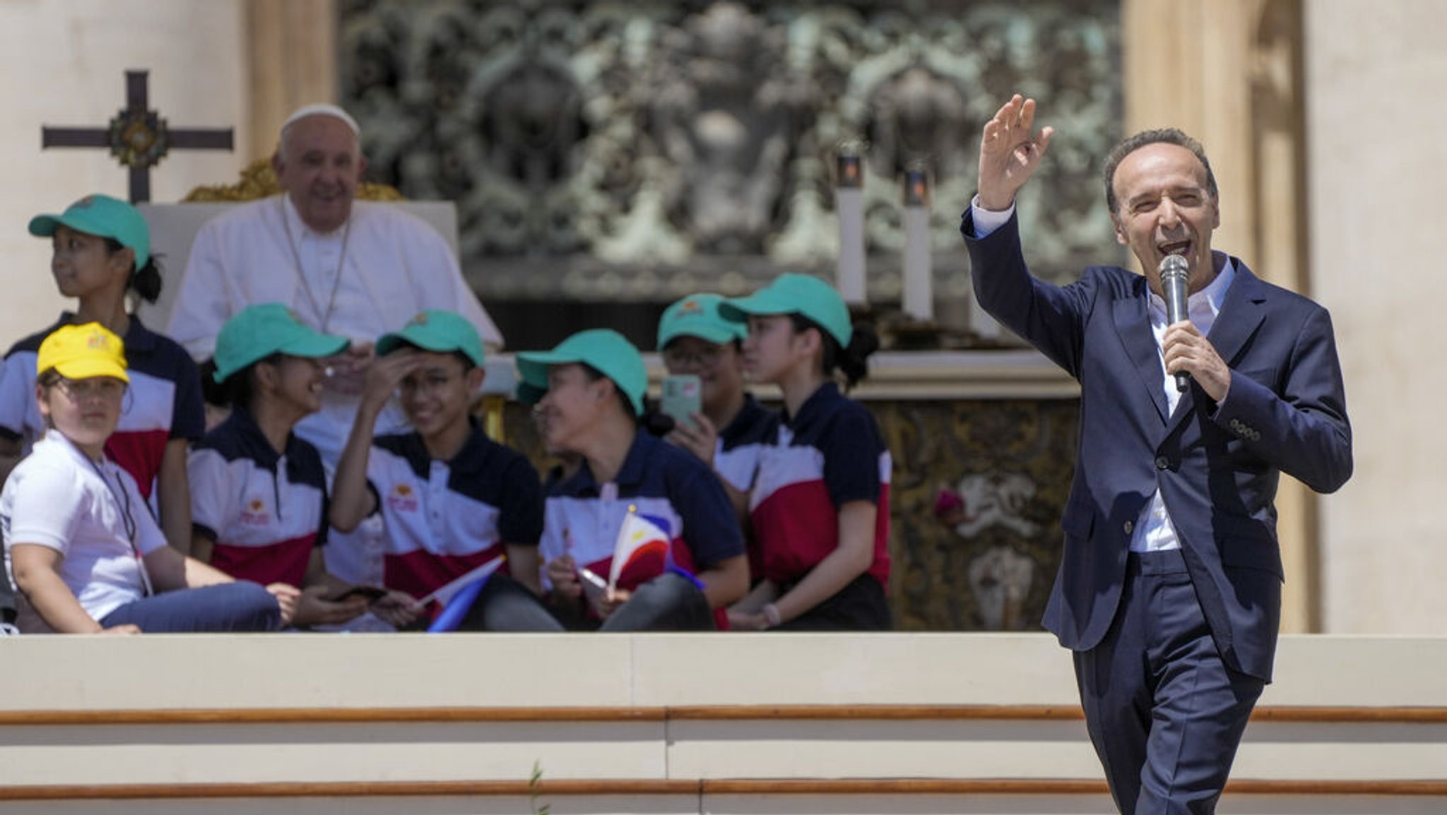 26.05.2024, Vatikan, Vatikanstadt: Der italienische Schauspieler und Regisseur Roberto Benigni (r) hält eine Rede, während Papst Franziskus einer Messe zum Weltkindertag auf dem Petersplatz im Vatikan vorsteht. Foto: Gregorio Borgia/AP/dpa +++ dpa-Bildfunk +++