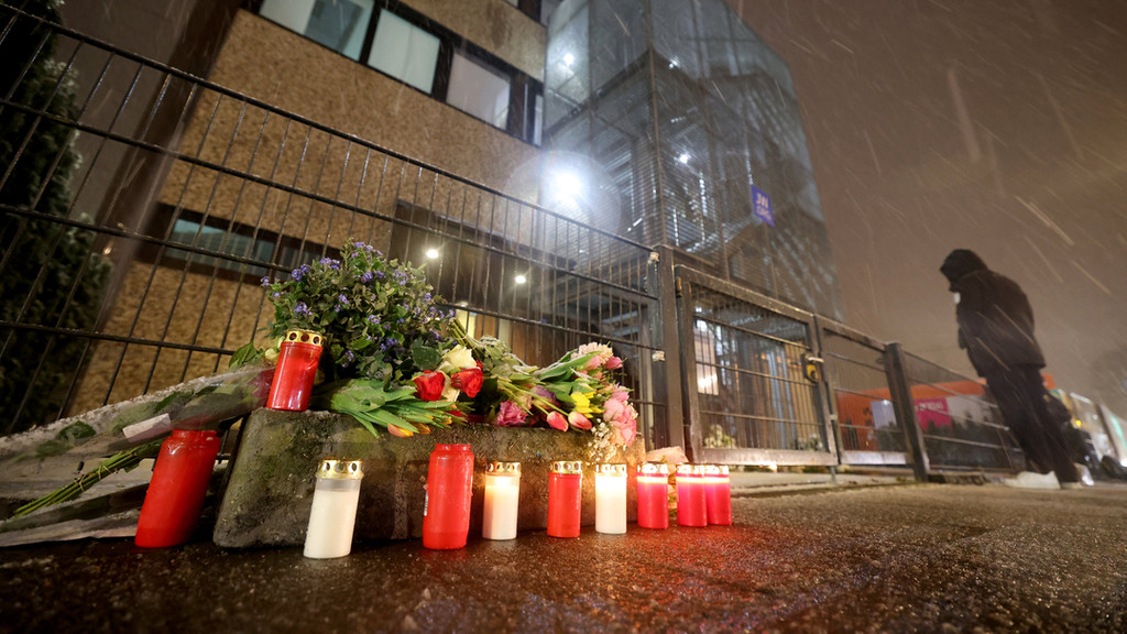 Grablichter und Blumen liegen und stehen vor dem Gebäude der Zeugen Jehovas im Stadtteil Alsterdorf.