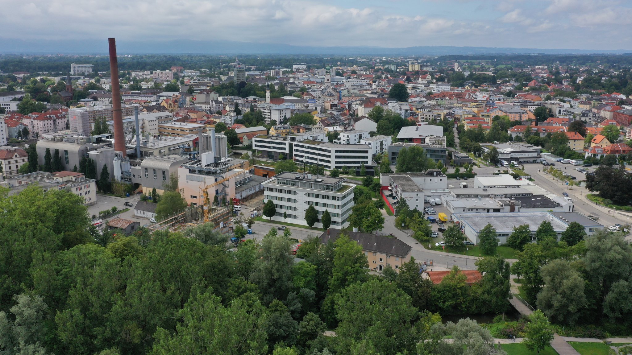 Vorne der südliche Teil des Mangfallparks, hinten die Stadt mit Industrieanlagen und Wohnvierteln