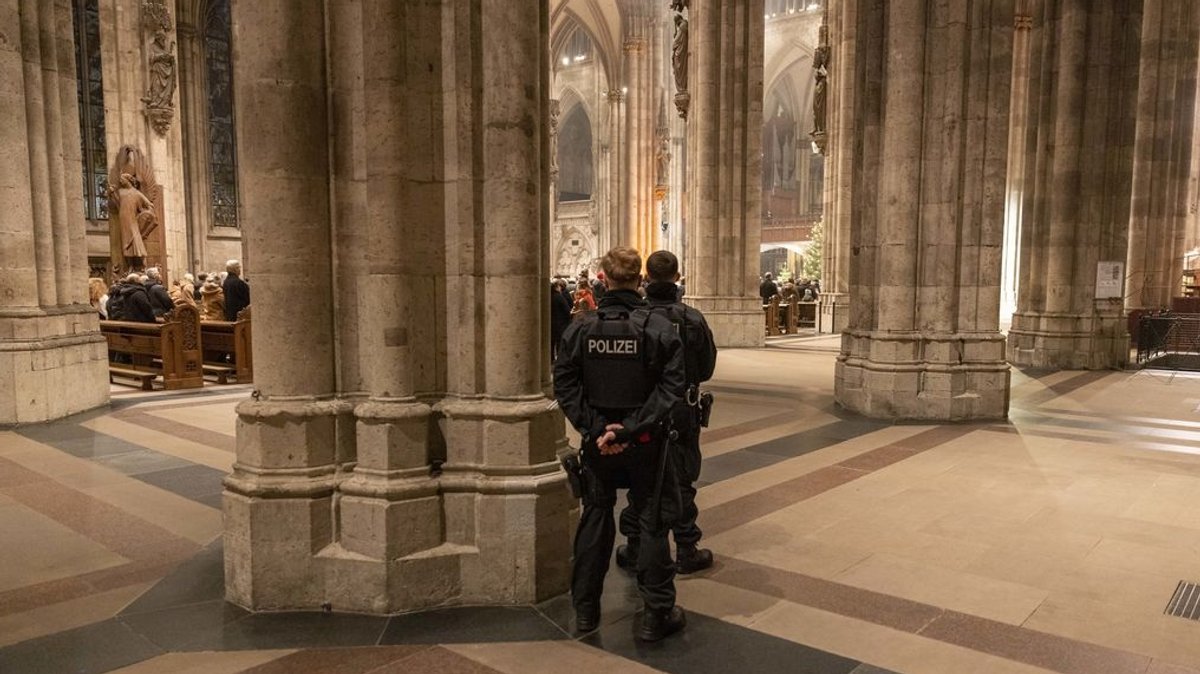 31.12.2023, Nordrhein-Westfalen, Köln: Polizeibeamte sichern während des Pontifikalamt zum Jahresabschluss den Kölner Dom. 