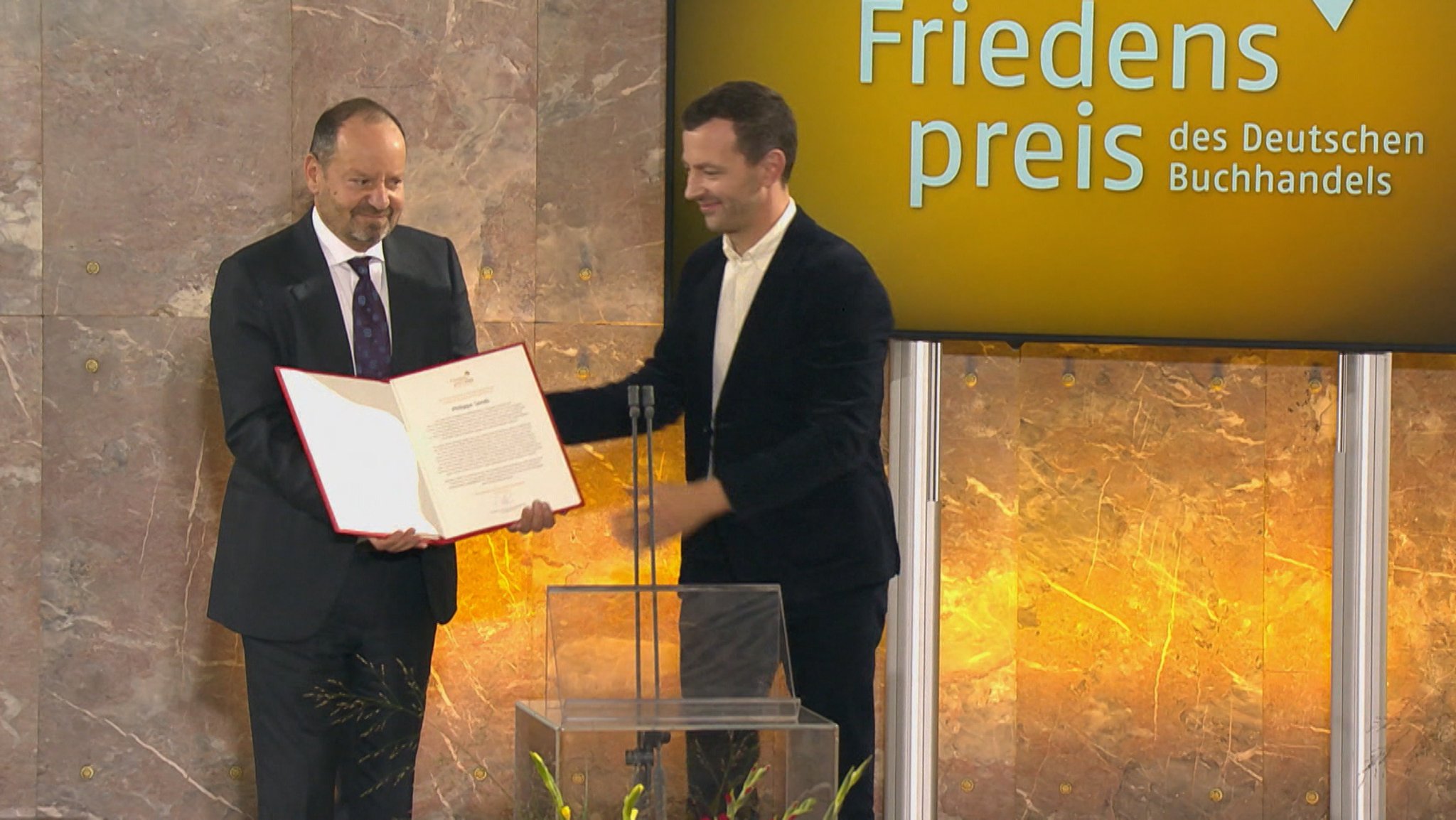 Der britisch-französische Schriftsteller und Völkerrechtler Philippe Sands ist mit dem Friedenspreis des Deutschen Buchhandels ausgezeichnet worden. Er nutzte seine Dankesrede für deutliche Kritik an Deutschland. | Bild: Bayerischer Rundfunk 2026 Der britisch-französische Schriftsteller und Völkerrechtler Philippe Sands ist mit dem Friedenspreis des Deutschen Buchhandels ausgezeichnet worden. Er nutzte seine Dankesrede für deutliche Kritik an Deutschland.