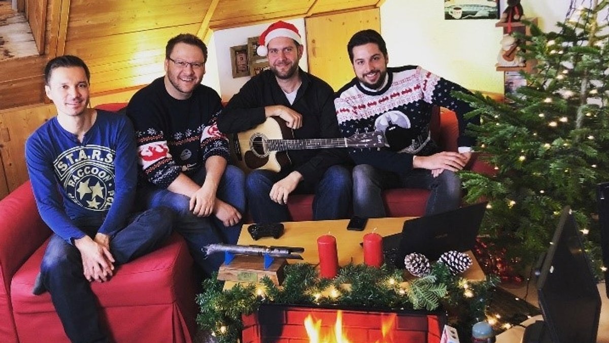 vier Gamer neben einem Weihnachtsbaum