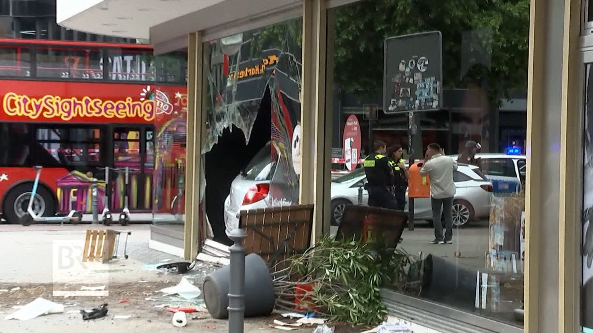 Auto steht im Schaufenster eines Geschäfts, die Scheibe ist durchbrochen.